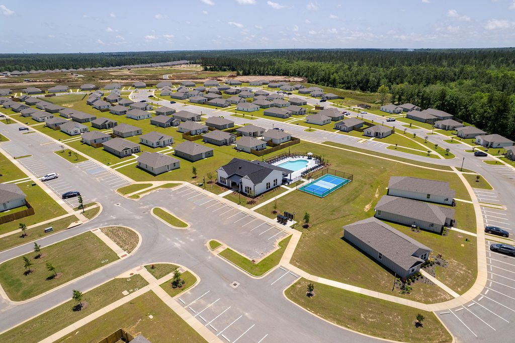 The living room features a gray sofa adorned with patterned throw pillows, two white geometric coffee tables, and a dark blue armchair